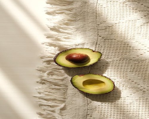 Perfectly ripe halved avocado showing the pit on a traditional Mexican textile background